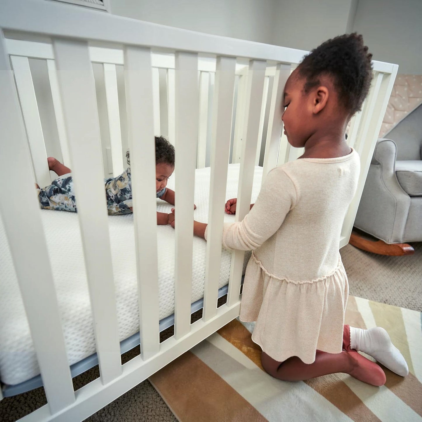Modugreen Baby white breathable crib mattress cover with 3D mesh, shown on a crib with a baby and older sister.