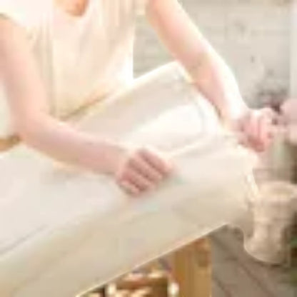 Modugreen Baby breathable organic cotton crib mattress cover being fitted onto a mattress in a bright nursery.
