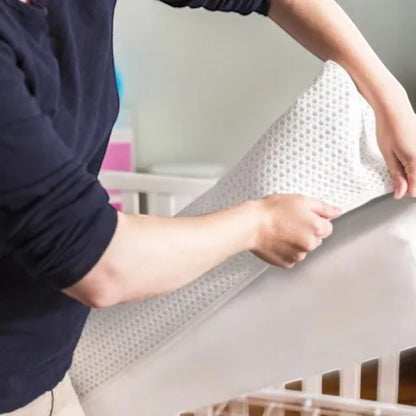 Modugreen Baby Breathe-Safe 2-Stage Crib Mattress with a removable, washable 3D mesh cover being placed on the core.