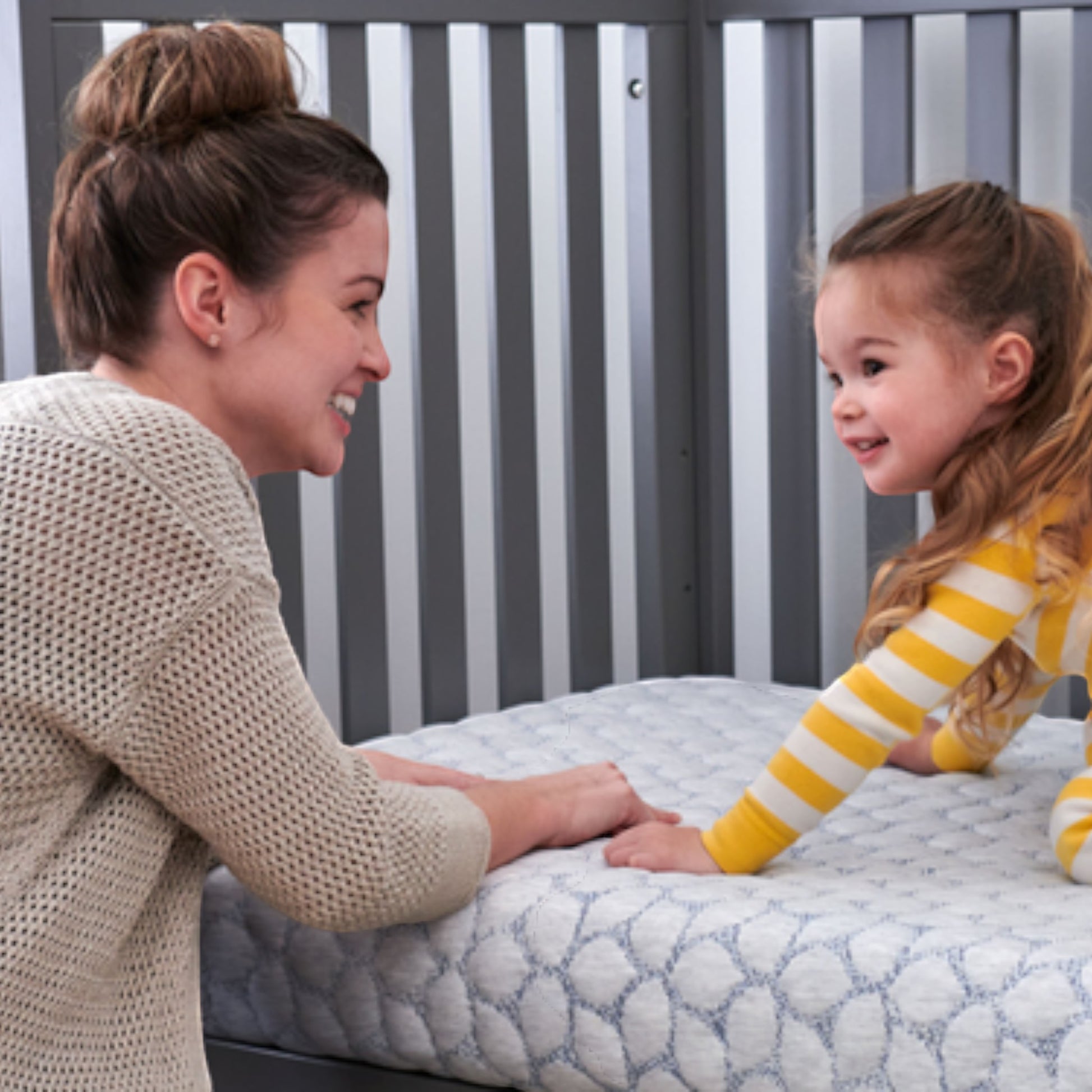Modugreen Baby Gentle Start breathable crib mattress with 3D lattice cover, shown with a mother and child in a nursery