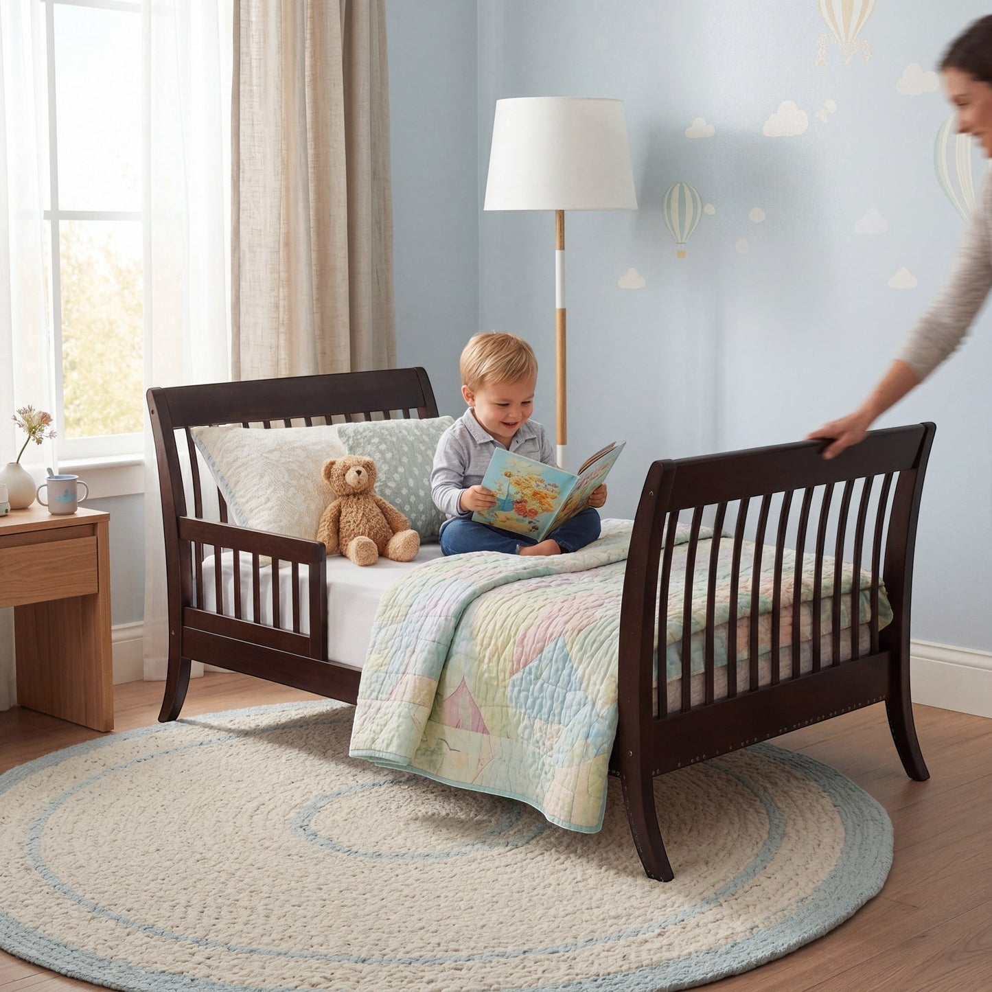 Modugreen Baby Laurel conversion kit transforming a slat crib into a toddler bed with a child reading in a nursery.