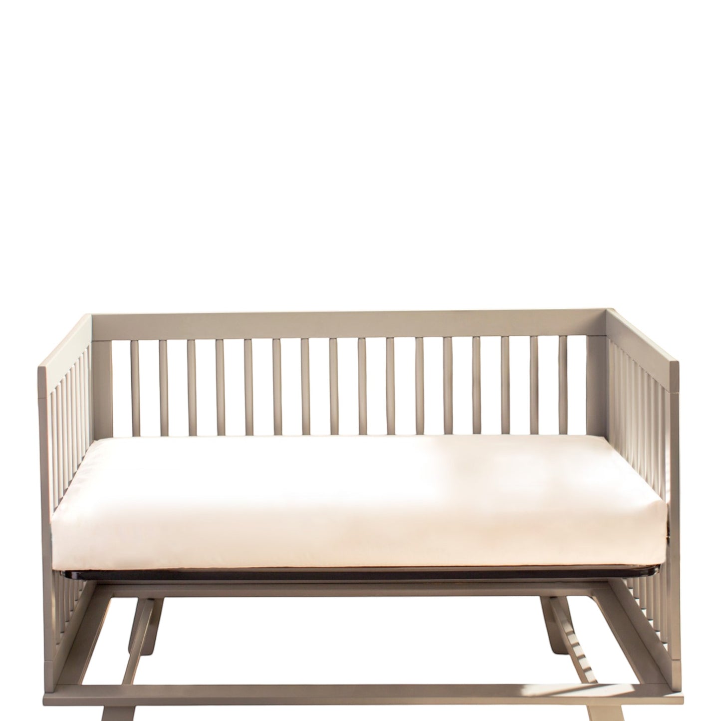Modugreen Baby Innerspring Classic organic cotton 2-stage crib mattress in a grey wooden crib frame.