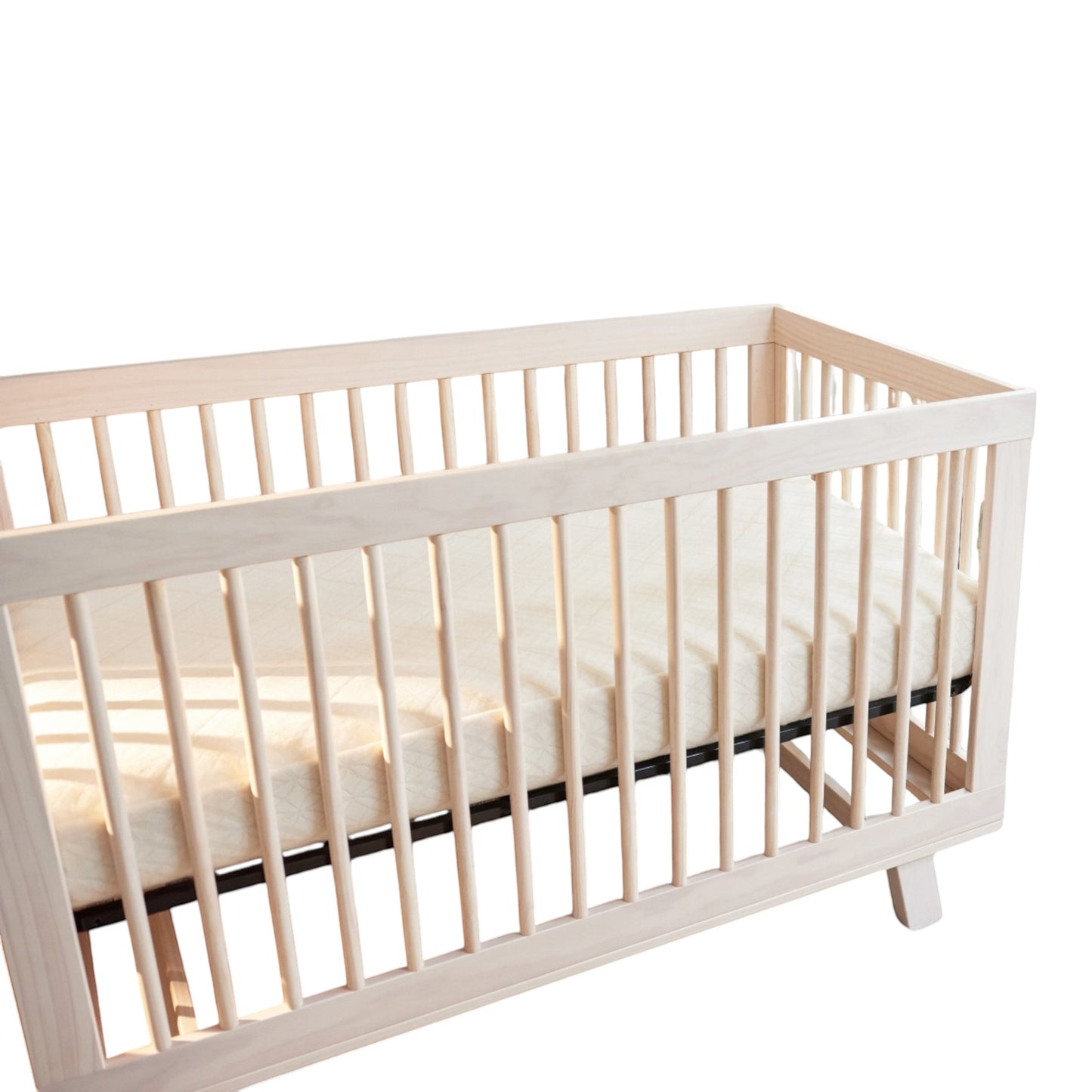 Modugreen Baby breathable organic 2-stage crib mattress with quilted cover inside a light wood slatted crib
