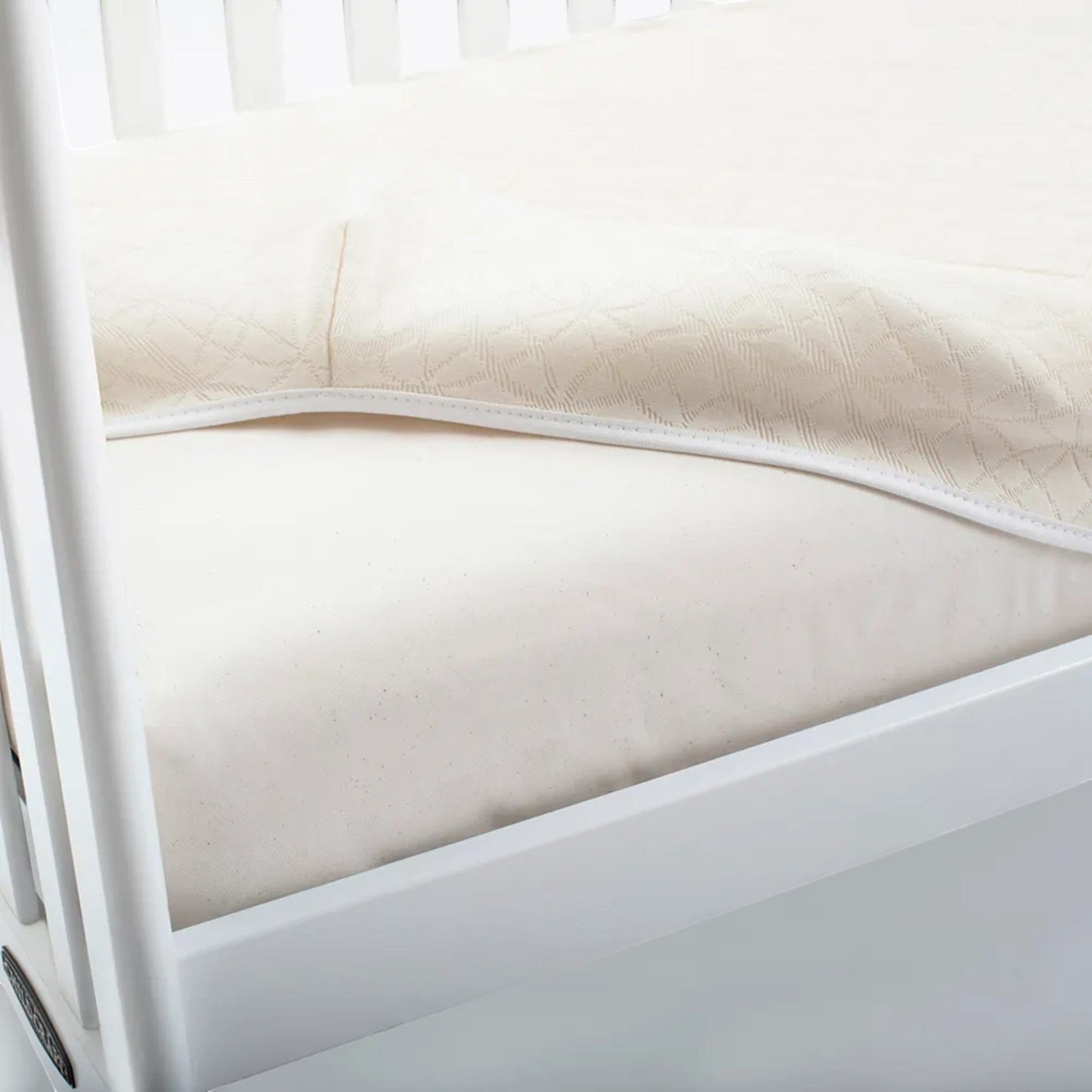 Modugreen Baby breathable organic cotton crib mattress cover with a quilted 3D lattice surface in cream.