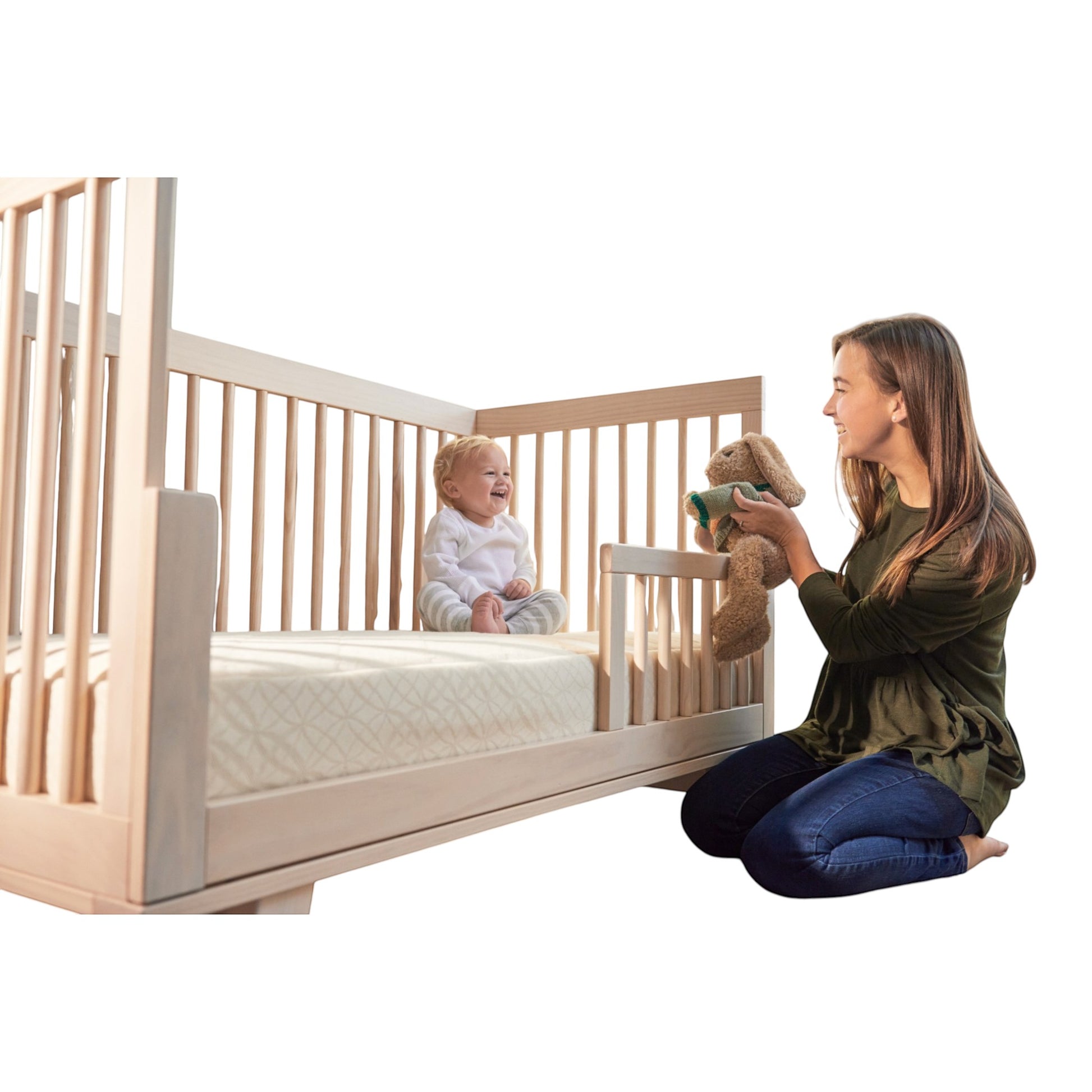 Modugreen Baby 2-stage organic crib mattress with quilted cover in a wooden crib with a smiling baby and mother.