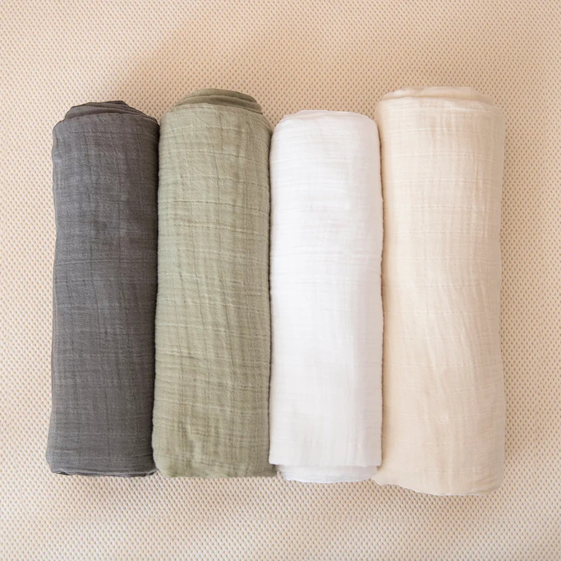 Modugreen Baby organic cotton muslin crib sheets in grey, sage green, white, and cream, featuring a soft crinkle texture.