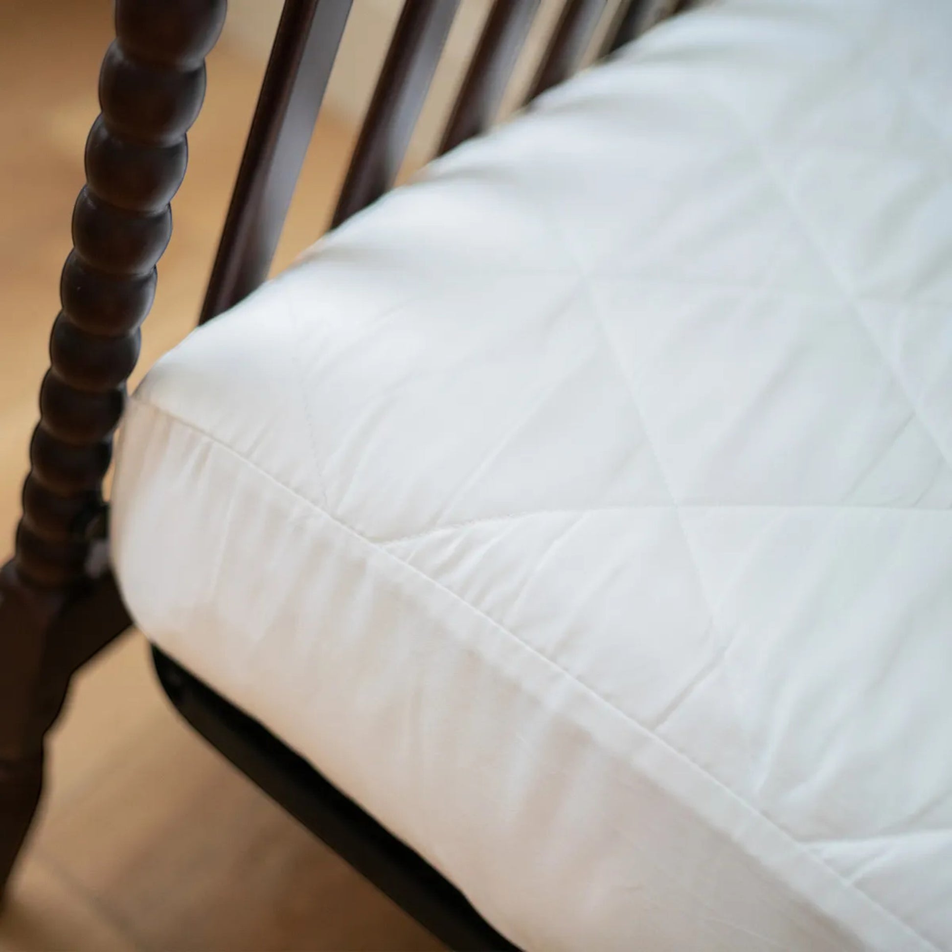 Modugreen Baby white organic quilted waterproof crib mattress protector pad with a soft cotton surface.