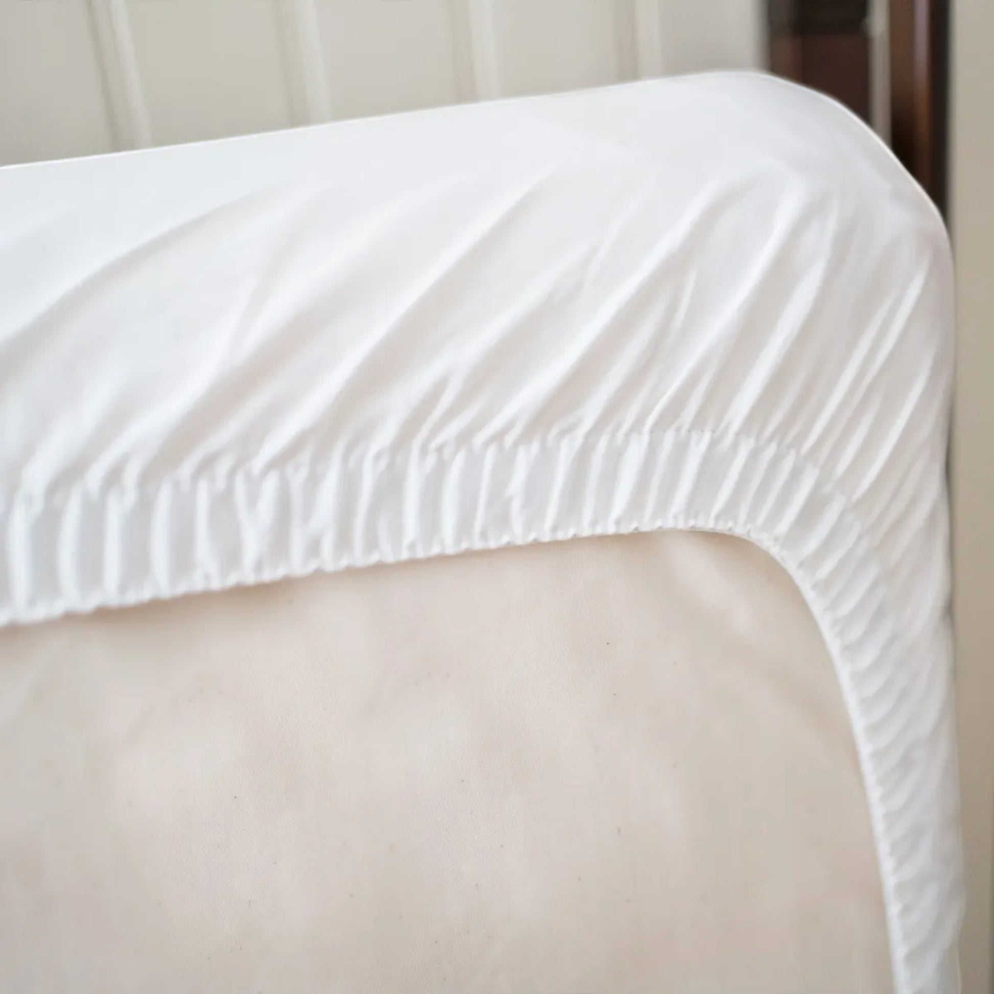 Modugreen Baby organic quilted waterproof crib mattress protector pad in white with a secure elastic fitted skirt.