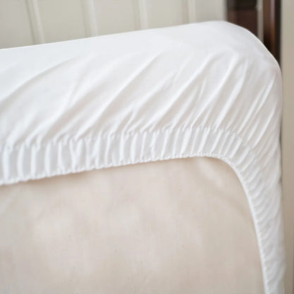 Modugreen Baby organic quilted waterproof crib mattress protector pad in white with a secure elastic fitted skirt.