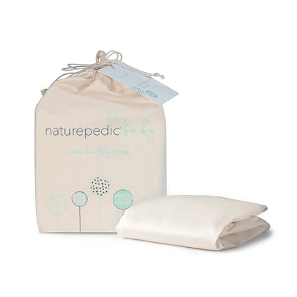 Modugreen Baby organic sateen crib sheet in ivory, folded next to its branded cotton storage bag.